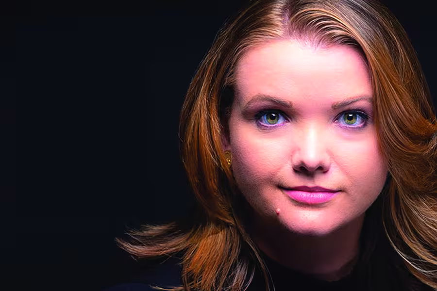 Portrait of author Téa Obreht facing the camera against a dark gray background.