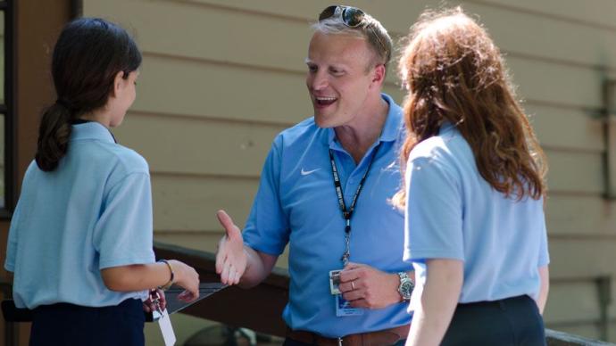 President Devey greets two junior girls during a Camp reception.