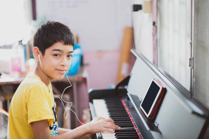 Interlochen Online - boy in yellow shirt plays the piano