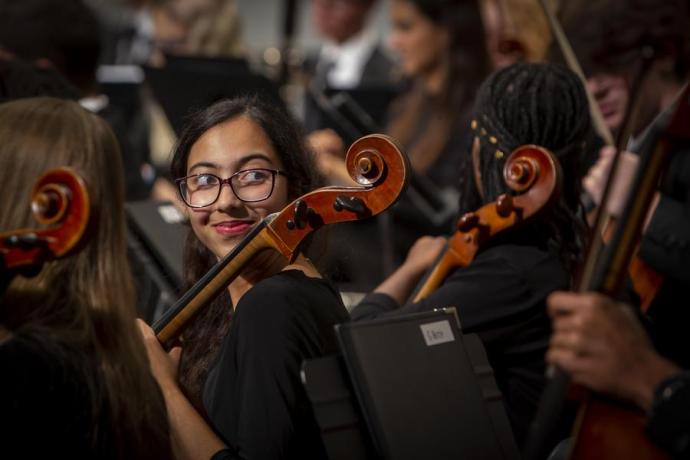 Interlochen Arts Academy Orchestra cellist smiles during performance