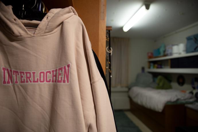 A pink "Interlochen" hooded sweatshirt hangs in an Arts Academy student's closet.