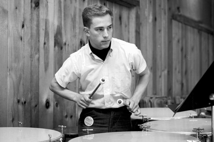 A black-and-white photo of Dr. Michael Bresler, M.D. playing timpani with the World Youth Symphony Orchestra during summer 1964.