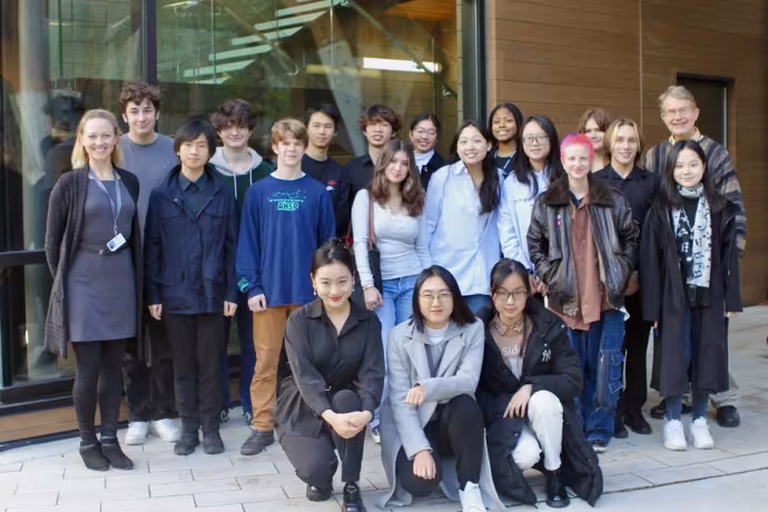 A group of students and teachers poses outside Interlochen's Music building.