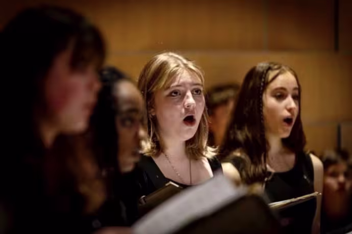A group of choir students sing.