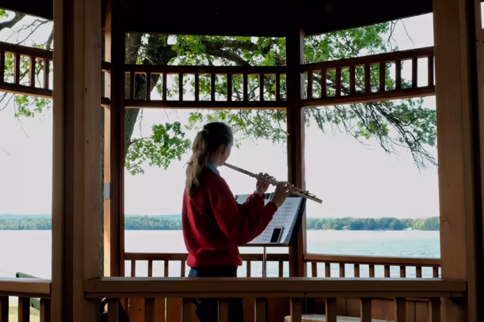 A student practices flute in a gazebo at Interlochen Arts Camp. 