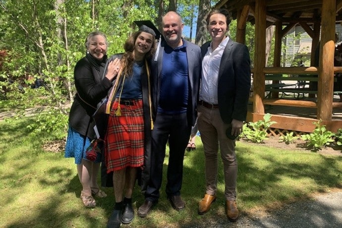 A family stands with their Arts Academy graduate in front of Interlochen's gazebo.