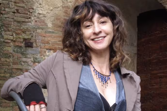 Headshot of a woman with curly brown hair in a suit
