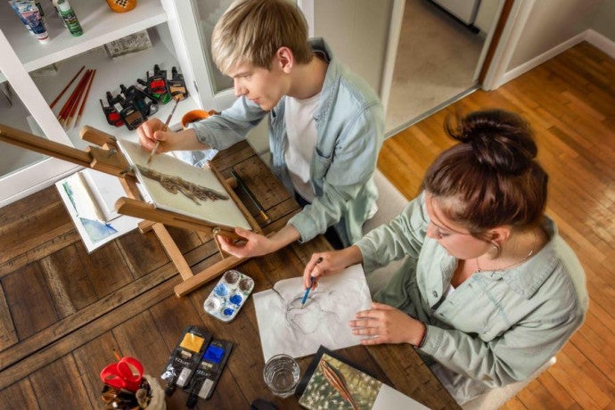 Two students work on visual arts projects.