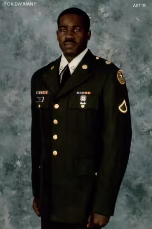A man poses in a military uniform