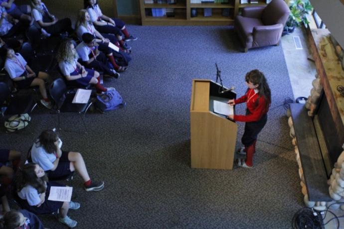 A creative writing student reading their work to an audience