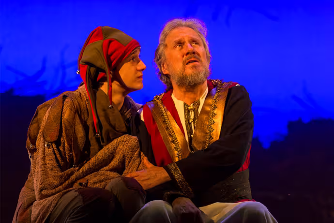 A man sits next to a court jester