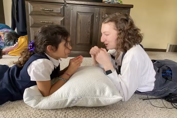 2 girls from Jedo's Dead cast facing and talking with each other with their elbos on a pillow 