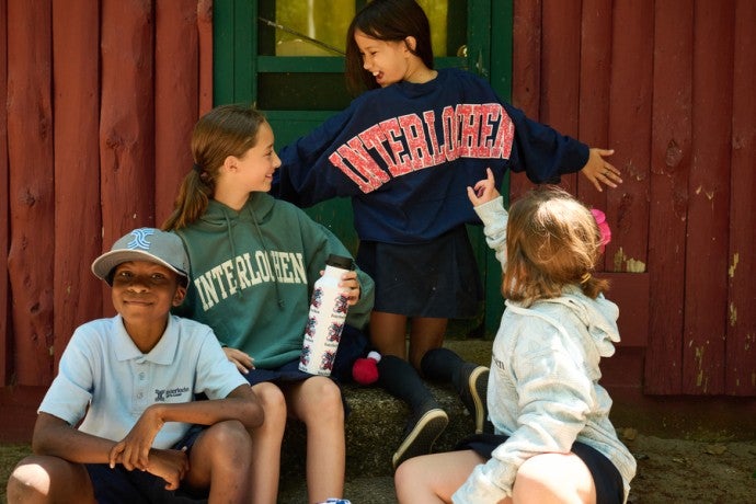 Interlochen Arts Camp friends talk on a cabin stoop