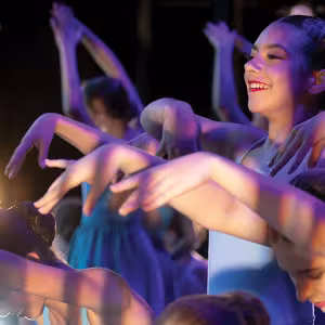 A group of young dancers in blue dresses
