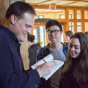 Garth Greenwell signs a book for an Arts Academy student