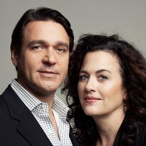 A well-dressed man and woman gaze into the camera for a professional headshot together.