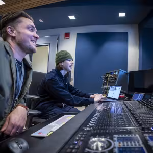 Student and an instructor working with professional music studio equipment