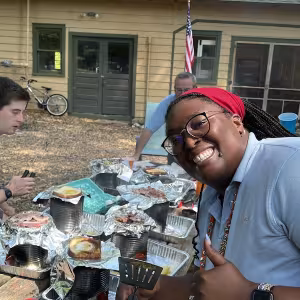 Jessi Woods smiles as she helps cook a Camp meal.