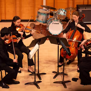A student string quartet performs at Kaufman Music Center's Merkin Hall during the March 2024 partner tour. 