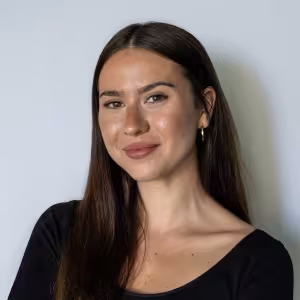 A dark-haired young woman smiles into the camera.