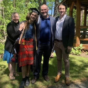 A family stands with their Arts Academy graduate in front of Interlochen's gazebo.