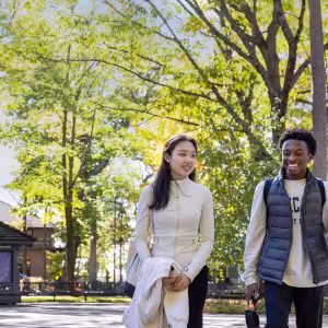 Two smiling Academy students walk on through Interlochen's campus