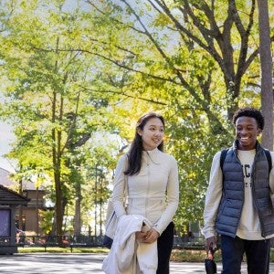 Two smiling Academy students walk on through Interlochen's campus