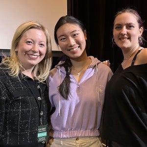 A guest artist poses with two students for a picture.