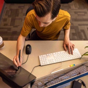 A student focuses intently at a computer.