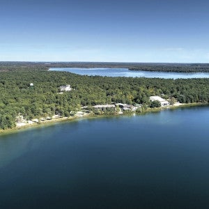 Aerial shot of Interlochen's campus showing the two lakes and pine forests