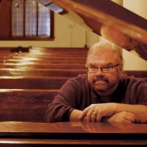 James Carter Cathcart sits at the piano.