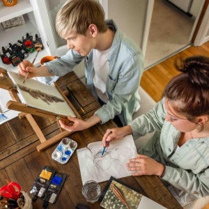 Two students work on visual arts projects.